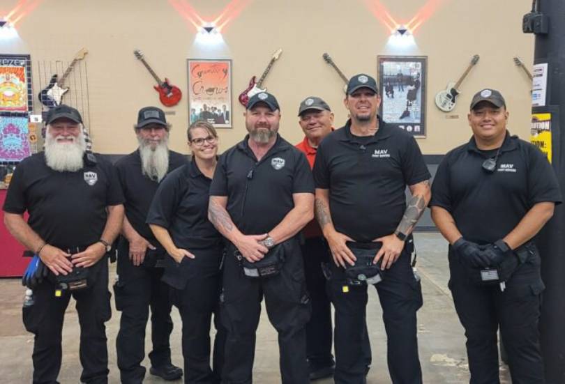 A group of men in black shirts and hats.